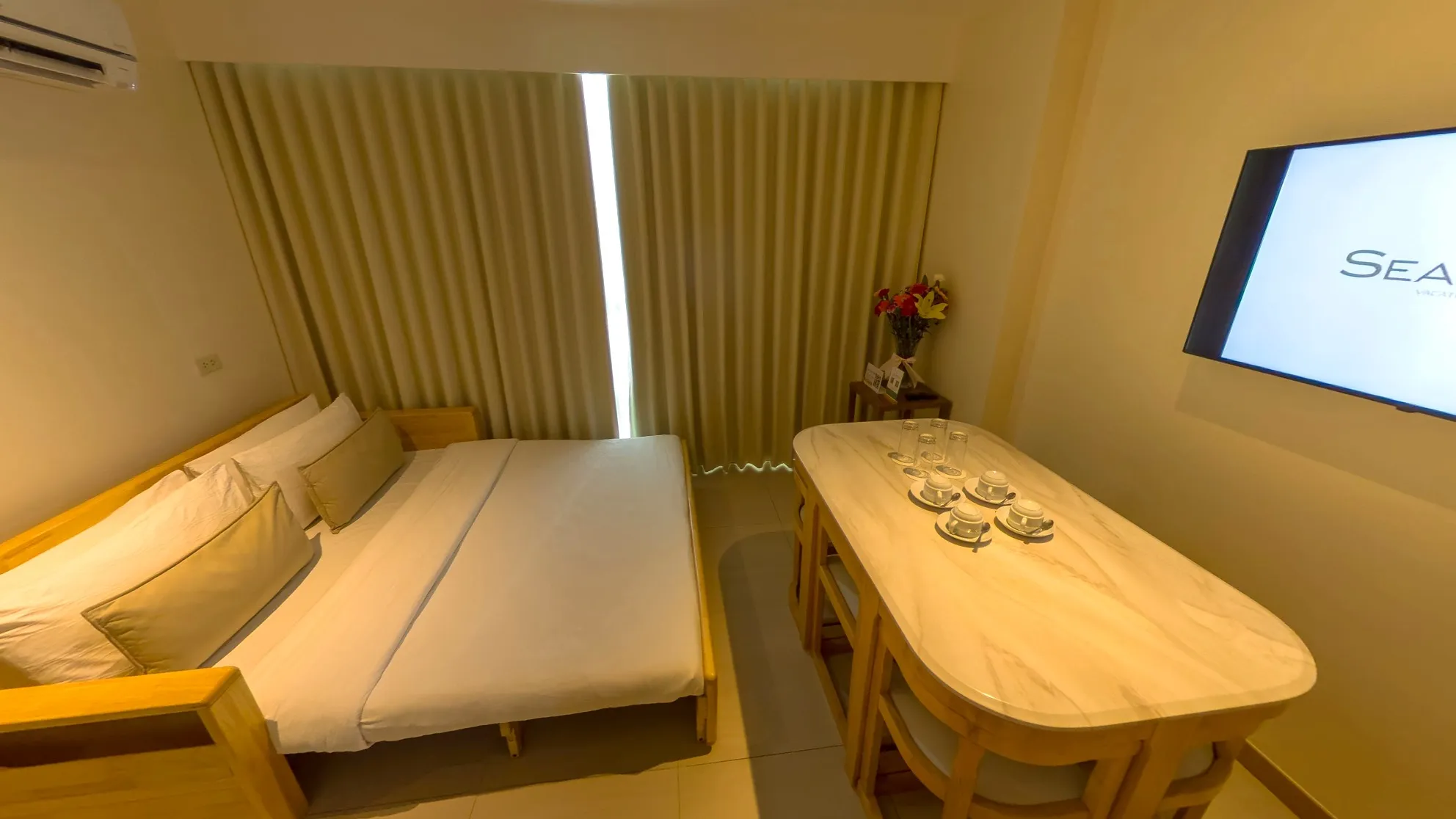 One Bedroom Standard Room with a queen bed and a dining table set for guests